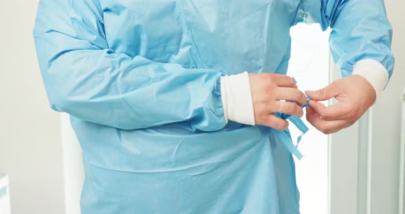 Closeup Male Veterinarian Hands on His Waist While He Ties a Belt Wearing a Surgical Outfit At the alt