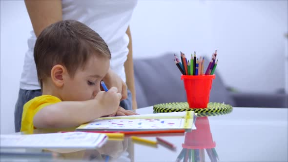 Happy Family Mother Nanny Learning Cute Baby Boy Playing Board Games at Home, Mom Helps Baby Son alt