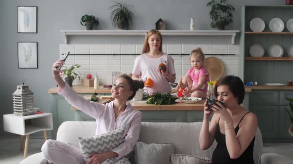 Three Women and Kid Sitting Together on Kitchen in Morning