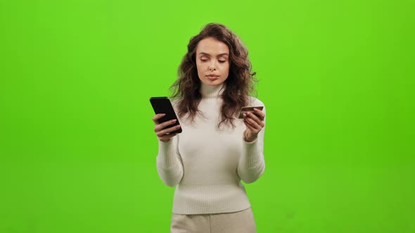 The Woman is Entering Her Bank Card Details Into Her Phone alt