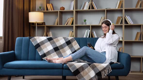 Head Shot Smiling Peaceful Woman Relaxing on Comfortable Couch Listening to Favorite Audio Music in alt