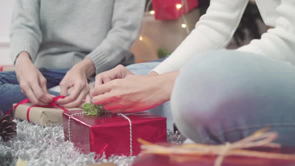 Lesbian Asian woman packing and wrapping Christmas present decorate in Christmas Festival.