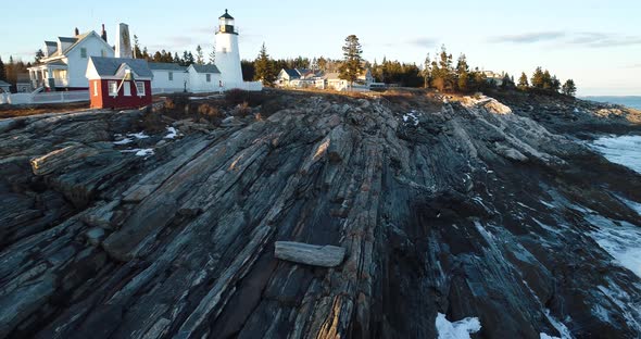 A man walking by the rocks in Curtis island lighthouse Camden Maine USA alt