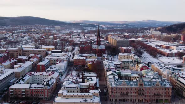 Aerial circling panoramic view of Sundsvall snowcapped city in Sweden with Gustav Adolfs church and alt