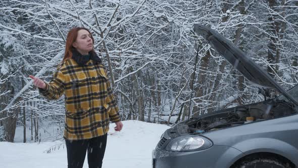 A Young Woman in a Winter Forest Stopping Cars Waiting for Help