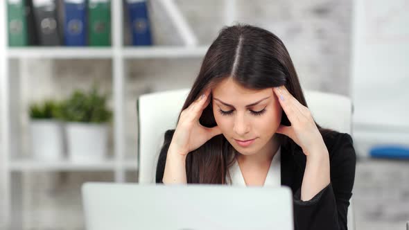 Tired Young Businesswoman Looking at Screen of Laptop at Office Medium Closeup alt