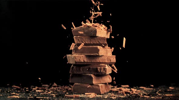 Super Slow Motion Fall of Grated Milk Chocolate on a Pyramid of Chocolate Slices alt