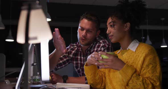 Young office executives discussing over computer in a modern office alt