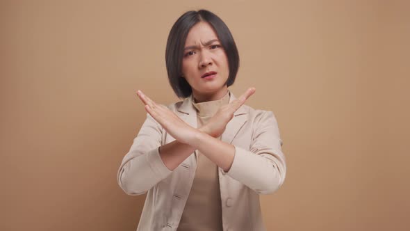 Asian business woman angry and crossed arms showing stop sign standing isolated