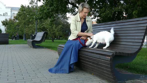 Woman Sitting in Park with Pregnant Dog alt