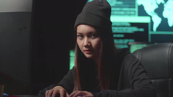 Woman Hacker Using Computer Hacking And  Looking, Pose To Camera, Code On Multiple Computer Screens alt