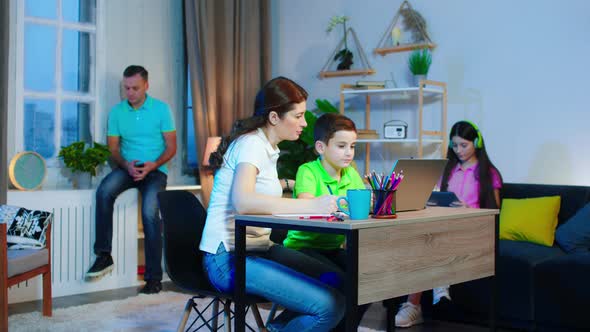 Happy Mother and Her Son Doing Together Homework alt