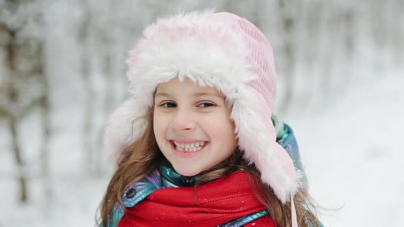 Portrait Llittle Child Girl in Winter Pink Hat in Snow
