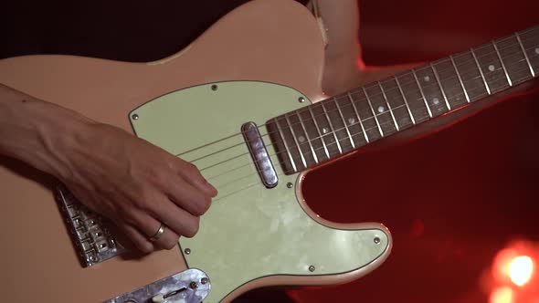 Professional Musician Playing on Electric Guitar in a Dark Studio with Smoke and Neon Lighting alt