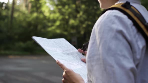 Tourist Girl Stands With A Map In The Middle Of The Forest Considering The Route, Summer Travel alt