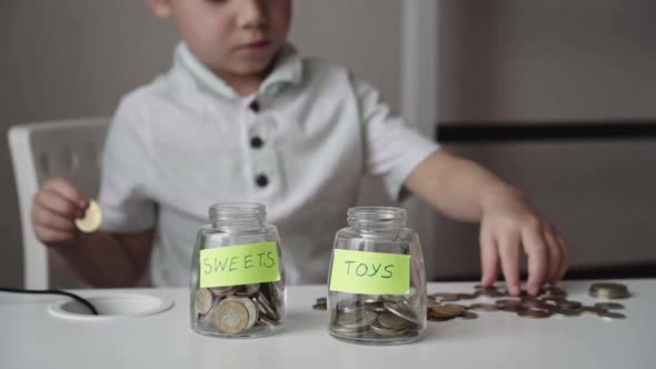 Little Caucasian Boy Putting Coin Into Glass Bottle