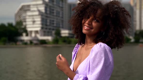 Sexual Black Woman with Funny Curly Hair Is Flirting with Camera, Dancing in Urban Landscape alt