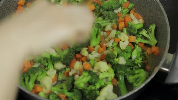 Mixing Fresh Vegetables on Frying Pan. Boiling Carrots, Cauliflower, Broccoli alt