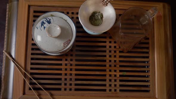 Close Up Hands of Tea Lover Taking Green Tea Cup From Wooden Table Top View alt