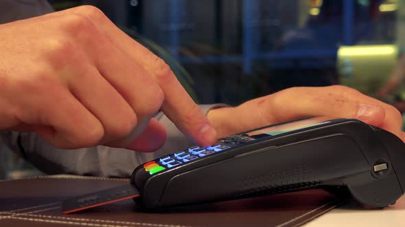 A Man Inserts a Credit Card Into a Scanner and Types in the Password - Closeup alt