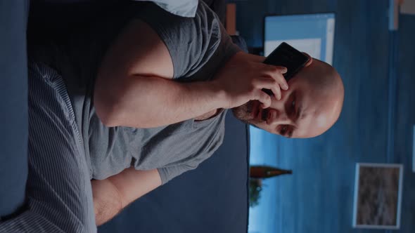 Vertical Video Astonished Man Talking at Phone Receving Horrible News alt