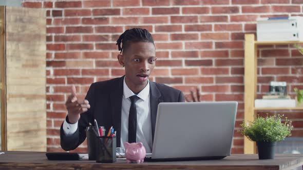 Disgruntled Black Man Businessman Indignantly Communicates By Video Link on the Laptop and Taking alt