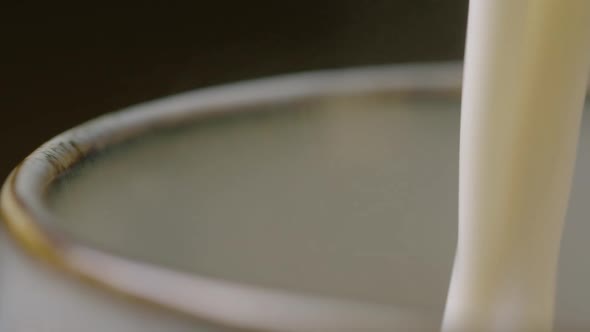 ZOOM OUT frothy milk is poured into a cup to make a cappuccino, 60fps alt