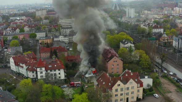 Firefighters Put Out Water From Hoses on a Burning Old Residential Building alt