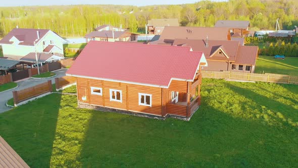 Wooden Cottage Houses with Red Roofs and Fresh Green Lawns alt