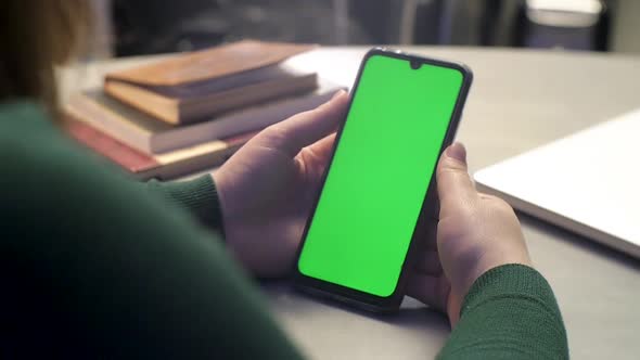 Girl holding a smartphone in the hands and using Phone Green Screen smartphone Android chrome key wa alt