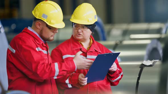 Two Workers in Production Plant As Team Discussing Industrial Scene in Background alt