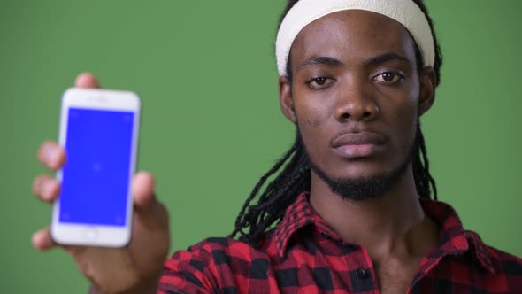 Young Handsome African Man with Dreadlocks Against Green Background alt