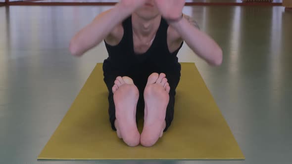 a Young Handsome Muscular Man Is Doing Yoga on a Mat
