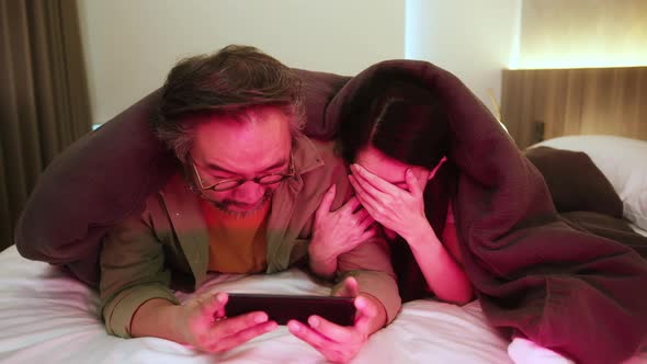happiness asian sweet couple husband wife enjoy tv program show from smartphone together