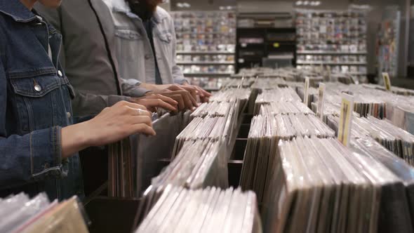 Unrecognizable Diverse Customers Looking through Vinyl in Record Store alt