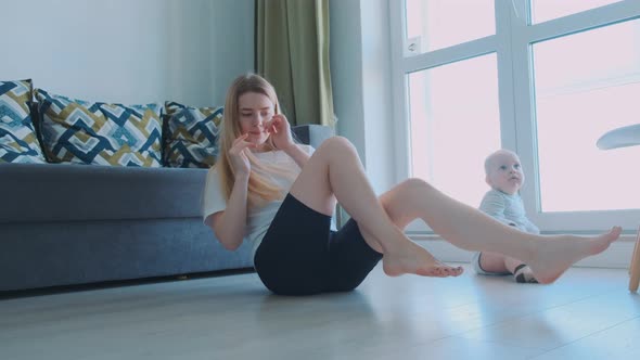 Young and Full of Energy Fit Mother Doing Her Morning Exercises at Home alt