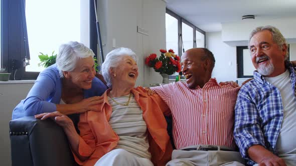 Happy senior friends having fun while relaxing on sofa 4k alt