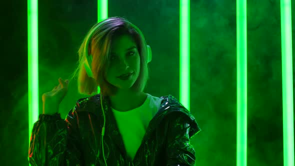 Portrait of a Young Stylish Woman in Big White Headphones Dances and Enjoys the Music. Close Up alt