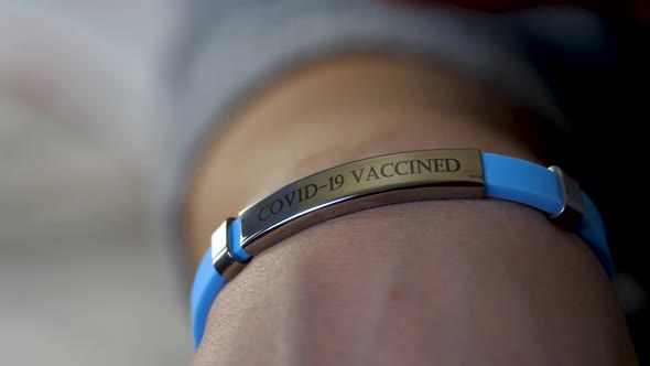 Female Member of Vaccine Programme Against Coronavirus with Vaccined Bracelet or Label on Hand