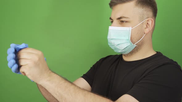 Caucasian Man Taking Off Protective Gloves and Face Mask and Smiling