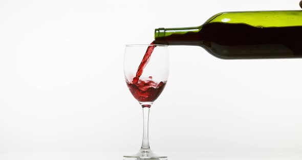 900126 Red Wine being poured into Glass, against White Background, Slow motion 4K alt