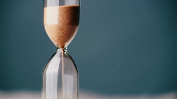 Countdown Hourglass Pouring on Blue Background alt