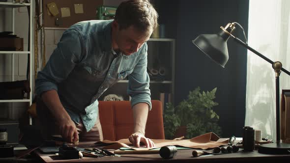 Man Tailor Cutting Cow Brown Leather with Stencil and Sharp Special Knife alt