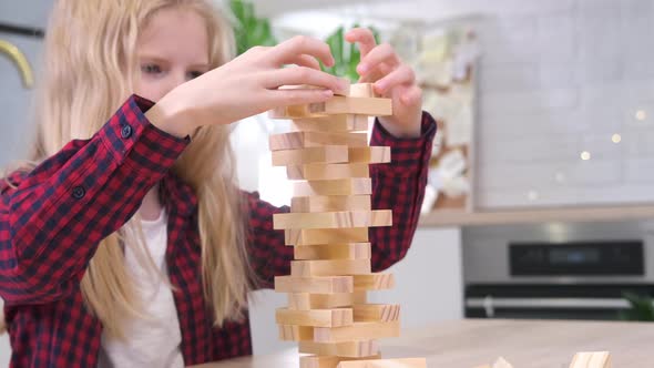 Children Playing Wooden Block Removal Tower Game at Home alt