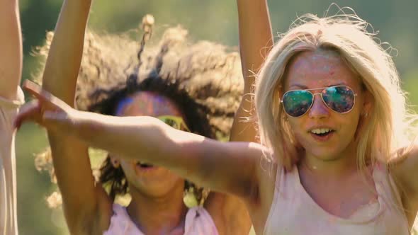 Excited Young People Jumping and Waving Hands to Camera, Enjoying Holi Festival alt