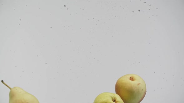 Fresh Fruits Red and Yellow Pears Falling Into Water with Splash and Air Bubbles White Background alt