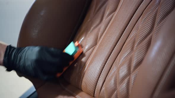 Car Detailing Service Worker Covering Leather Seat of an Expensive Car with Liquid Protective