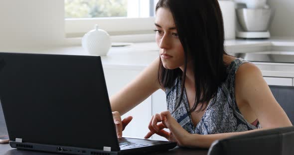 young woman concentrated reading and writing with a laptop