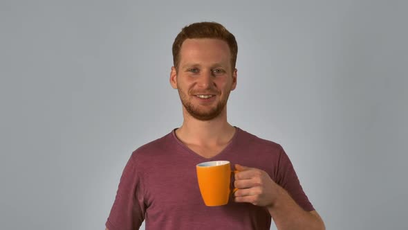Ginger Student Holds Mug with Happy Smile alt