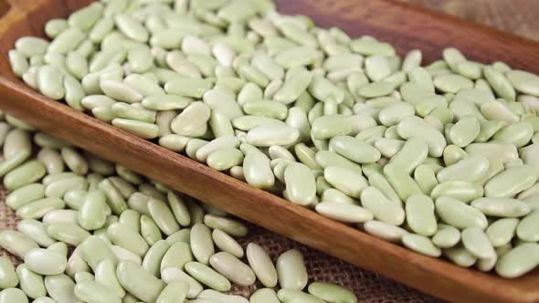 Dry green Verdina beans falling into wooden ware close up. Uncooked ...